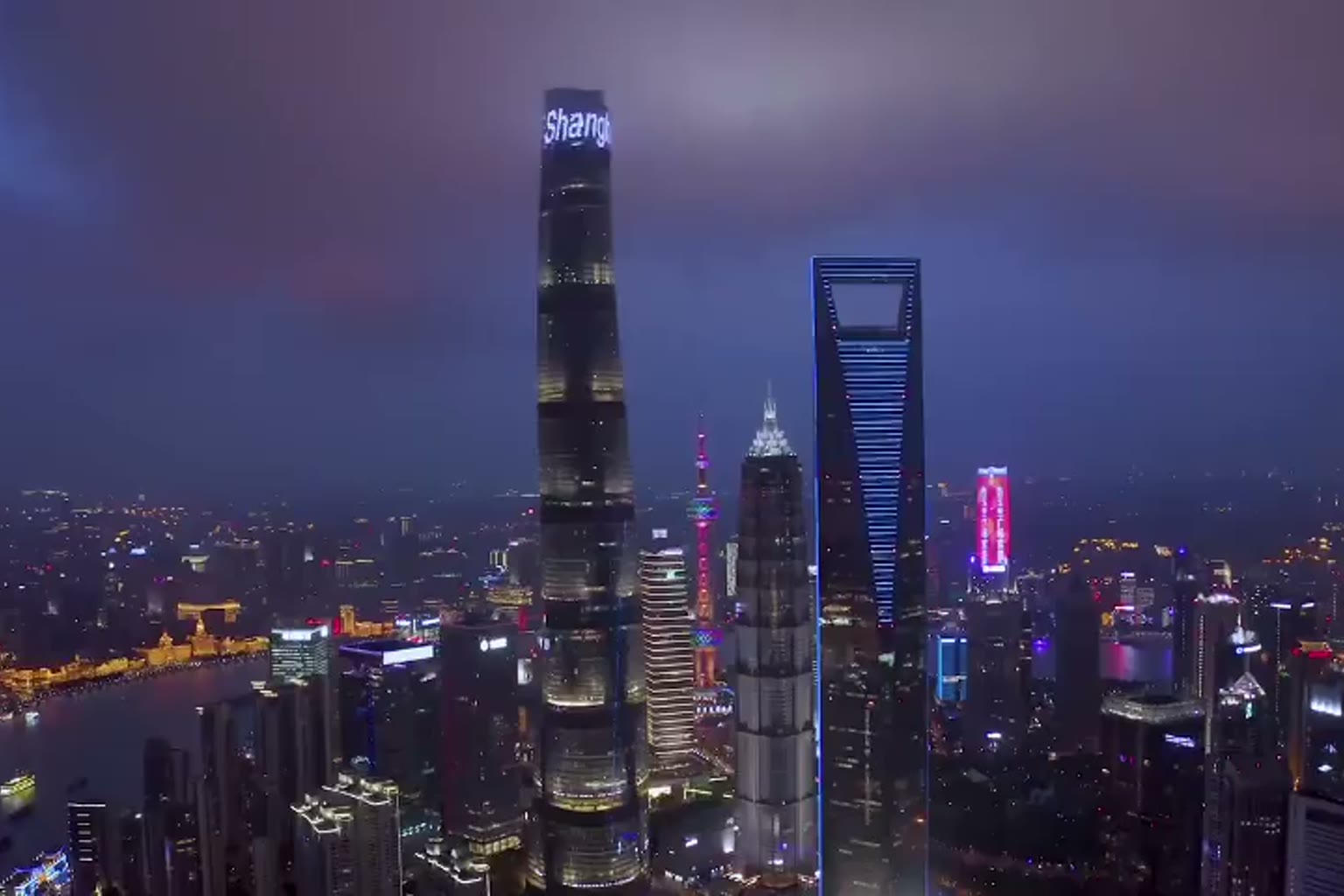 Night towers glowing above a river city